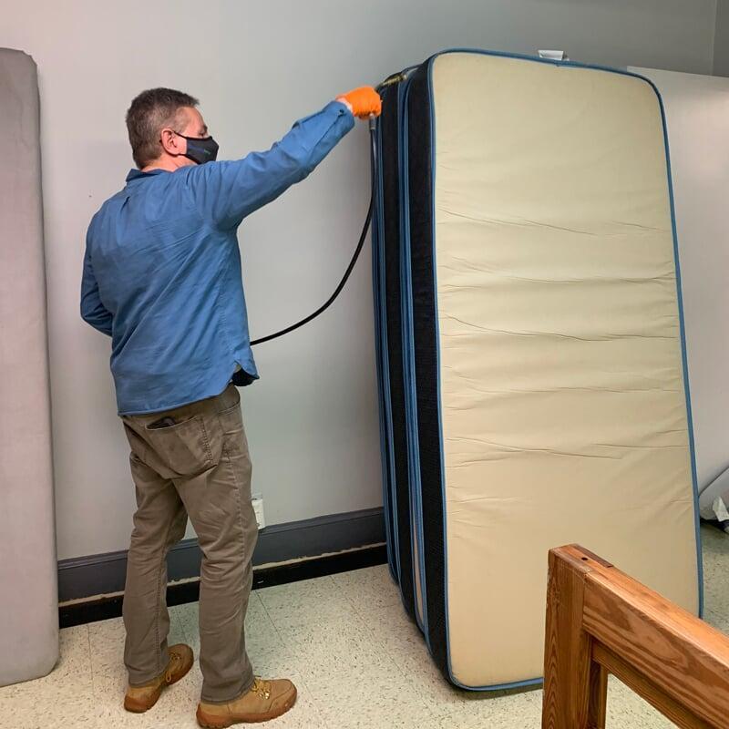 Performing a bed bug treatment.
