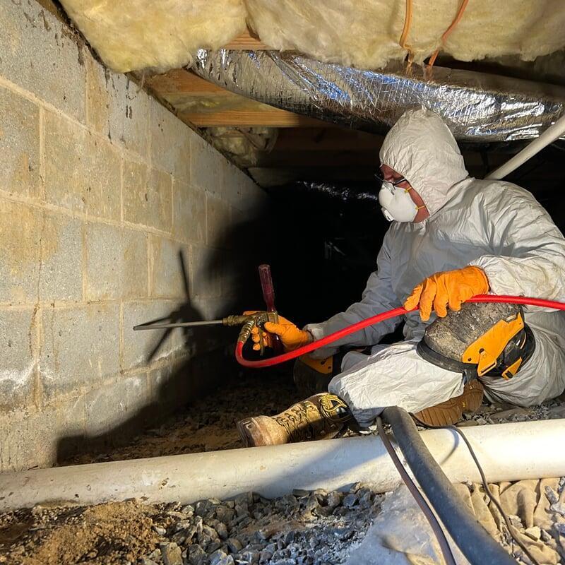 Technician drilling and rodding a foundation to treat a termite infestation.